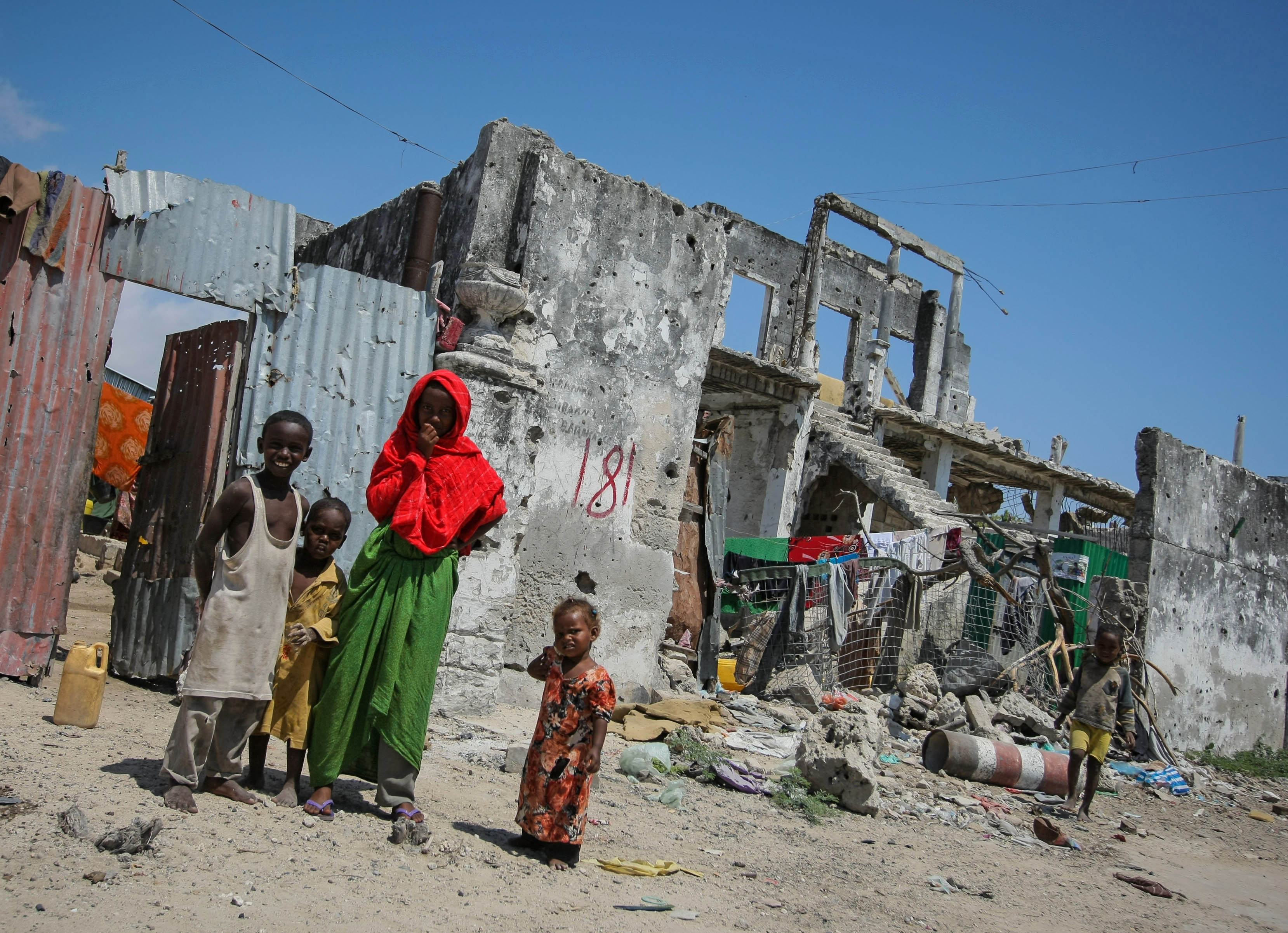 SOMALIA, Mogadishu: In a photo taken 09 November and released by the African Union-United Nations Information Support Team 10 November, Somali children are seen standing in front of their homestead in a derelict building in the Abdul-Aziz district of the Somali capital Mogadishu. The United Nations Security Council on November 7 renewed the mandate of the African Union Mission in Somalia (AMISOM) peacekeeping force for a further four months to continue providing support to the Government of Somalia in its efforts to bring peace and stability to the Horn of African country. AU-UN IST PHOTO / STUART PRICE.