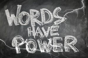 Words written with white chalk on chalkboard that reads "Words Have Power".