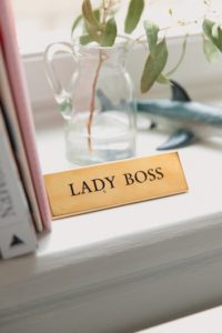 Sign with "LADY BOSS" written on it, sitting on a window sill.