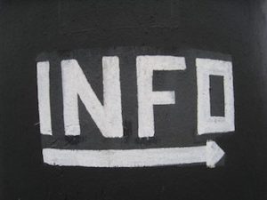 White chalk on blackboard that says "INFO" with an arrow drawn beneath it.