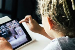 Child using an iPad tablet.