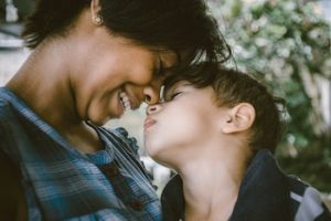 Mother and son, forehead to forehead, in an affectionate moment.