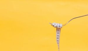 Yellow background with tape measure on fork