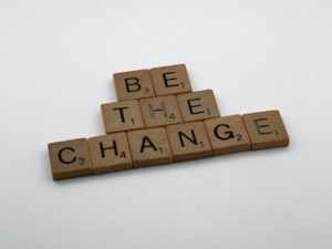 Scrabble letters spelling out "Be The Change".