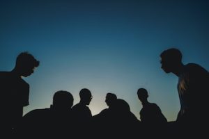 Group of friends stand in a circle with backlit starlight.