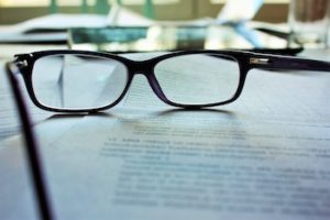 black framed eyeglasses sitting on book