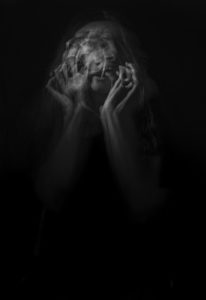 Black and white photo of a woman moving her head with long exposure captured