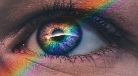 An open eye with a rainbow over it.