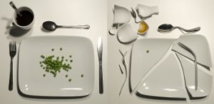 Two plates sit side by side, one with a few peas on it, the other broken into pieces.
