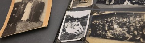 An old family photo album, open, revealing the yellowed and black-and-white photos within.