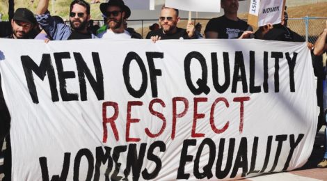 Men holding banner supporting equal rights for women.