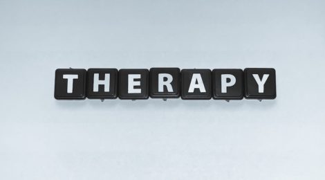 the words therapy in black and white scrabble pieces