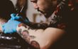 Tattoo artist tattooing a client