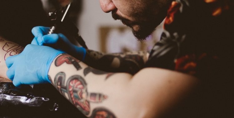 Tattoo artist tattooing a client