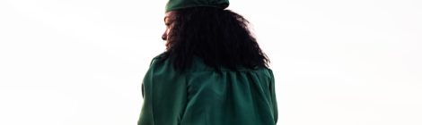 Graduate Student in Green Robe Looks Over Ledge