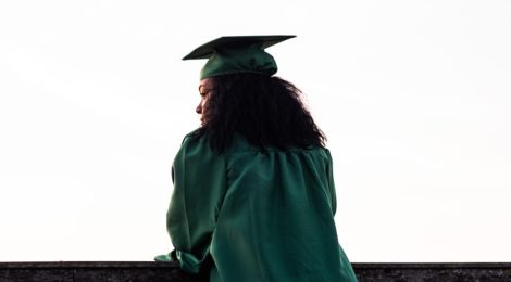 Graduate Student in Green Robe Looks Over Ledge